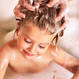 girl getting her hair washed for lice treatment